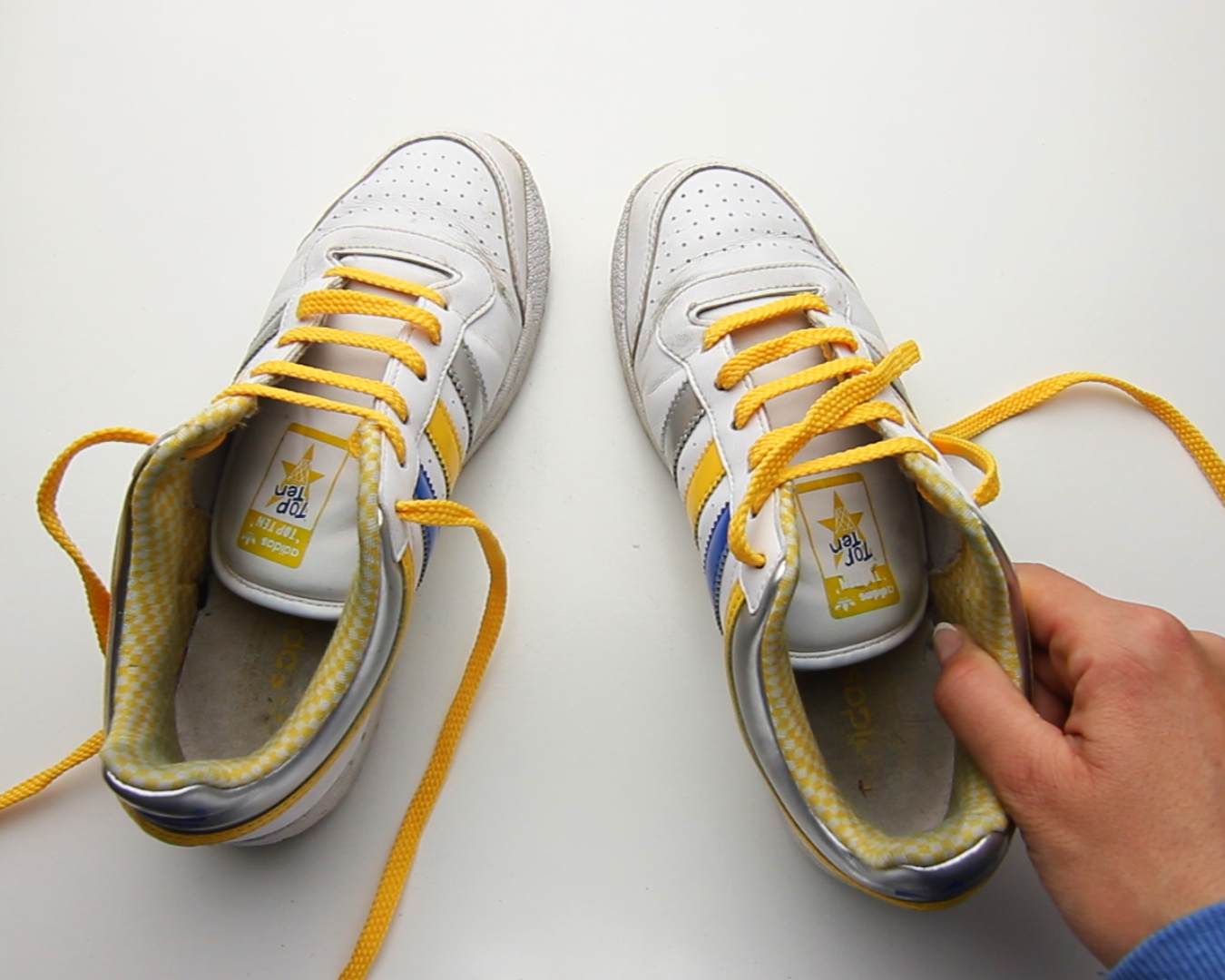 Как завязать кроссовки чтобы не торчали шнурки. Способы завязывания шнурков. Кроссовки со шнурками. Желтые шнурки. Завязанные кроссовки.